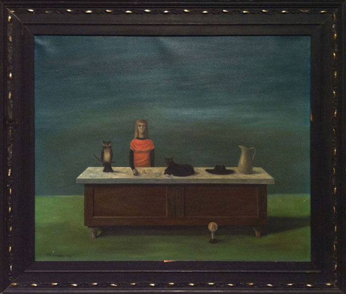 Surrealist painting of a person standing behind a centrally placed table covered with objects